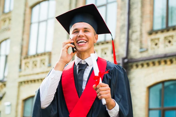 Graduating boy talking on cell phone — Stock Photo, Image
