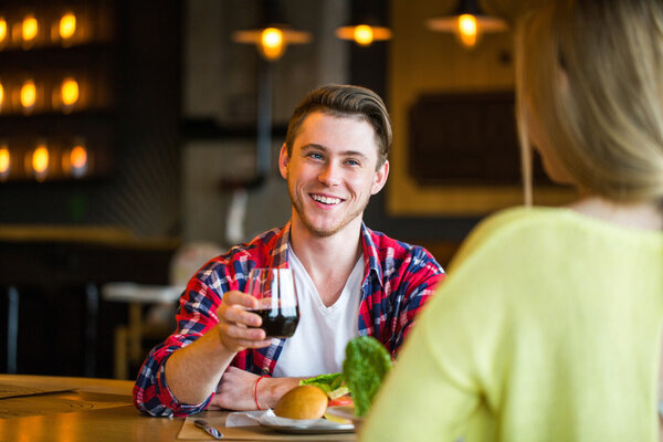 Young man and woman drinking wine in a restaurant. Young man and woman drinking wine on a date. man and woman on a date