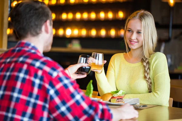 젊은 남자와 여자는 레스토랑에서 와인을 마시는 젊은 남자와 여자를 날짜에 와인을 마시는 남자와 여자를 날짜에 — 스톡 사진
