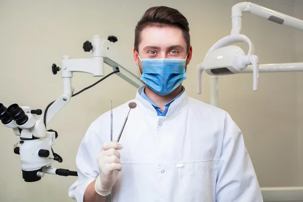 People, medicine, stomatology and healthcare concept - happy young male dentist with tools over medical office background — Stock Photo, Image