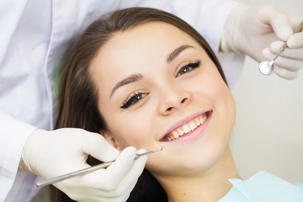 Primo piano della giovane donna durante l'ispezione della cavità orale con l'aiuto di gancio e specchio — Foto Stock