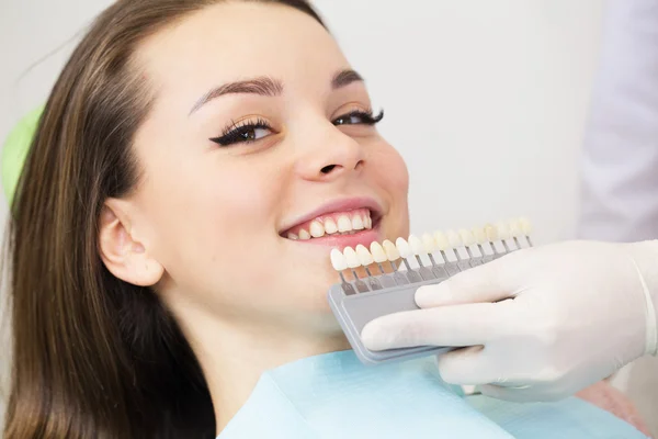 Gros plan portrait de jeunes femmes dans la chaise de dentiste, Vérifiez et sélectionnez la couleur des dents. Le dentiste rend le processus de traitement dans le bureau de la clinique dentaire — Photo