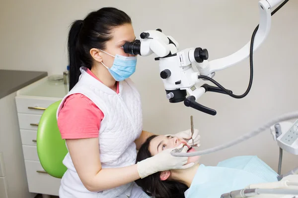 Paciente dentista profissional exame com microscópio — Fotografia de Stock