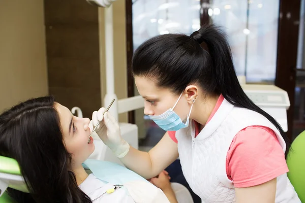 Dentist cleaning teeth of patient — Stock Photo, Image