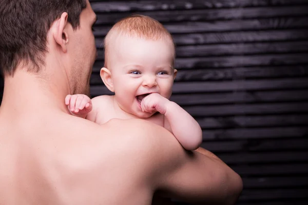 Joven padre está alimentando a su hija bebé. niña sonriendo a las manos del padre —  Fotos de Stock