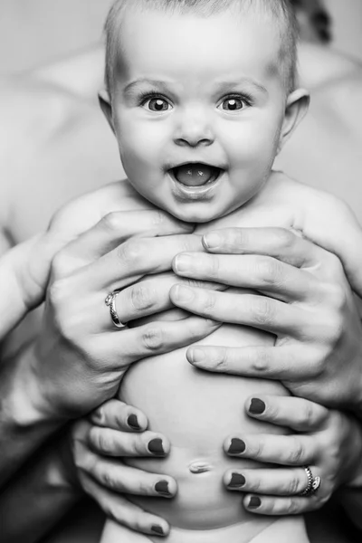 Joven padre está alimentando a su hija bebé.niña sonriendo a las manos del padre.blanco y negro —  Fotos de Stock