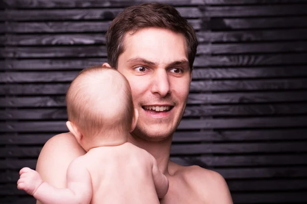 Joven padre está alimentando a su hija bebé. niña sonriendo a las manos del padre —  Fotos de Stock