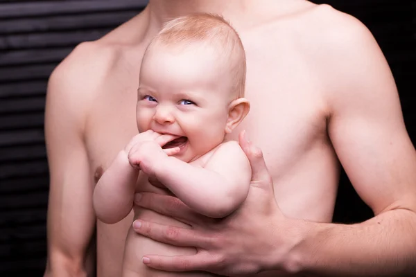 Joven padre está alimentando a su hija bebé. niña sonriendo a las manos del padre —  Fotos de Stock