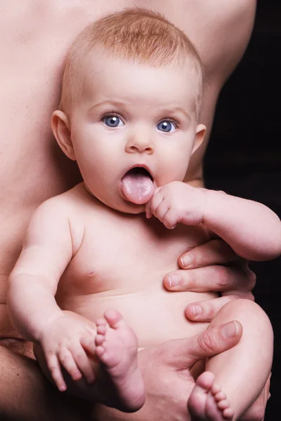 Joven padre está alimentando a su hija bebé. niña sonriendo a las manos del padre —  Fotos de Stock