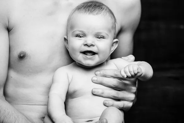 Jovem pai está alimentando seu bebê Filhter.baby menina sorrindo às mãos do pai.black e branco — Fotografia de Stock