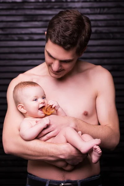 Joven padre está alimentando a su hija bebé. niña sonriendo a las manos del padre —  Fotos de Stock