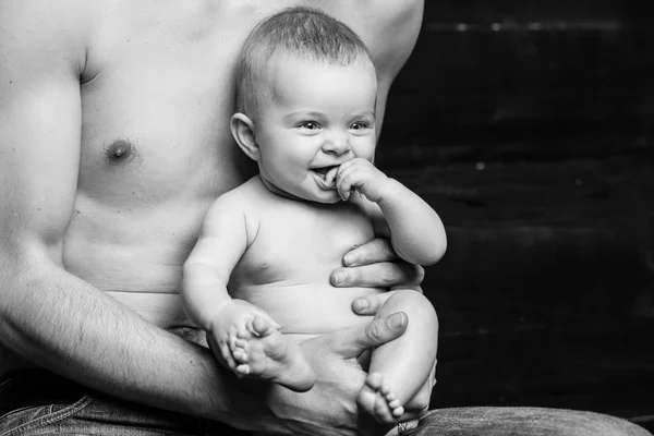 Junger Vater füttert seine kleine Tochter. Baby-Mädchen lächelt in den Händen des Vaters. Schwarz-weiß — Stockfoto