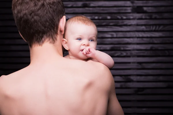 Joven padre está alimentando a su hija bebé. niña sonriendo a las manos del padre —  Fotos de Stock