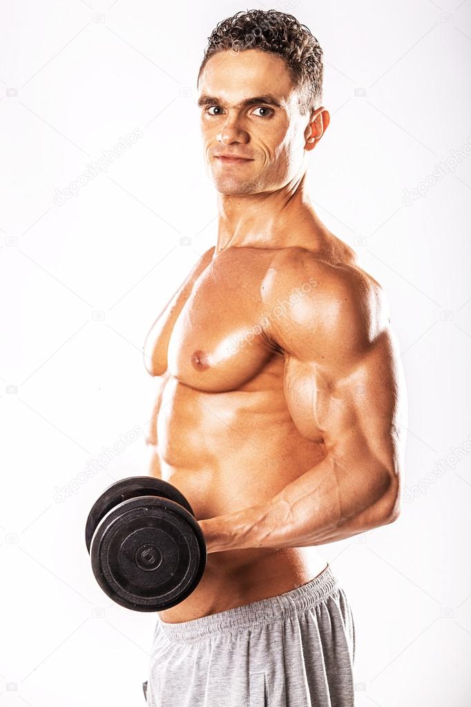 Muscular guy doing exercises with dumbbell