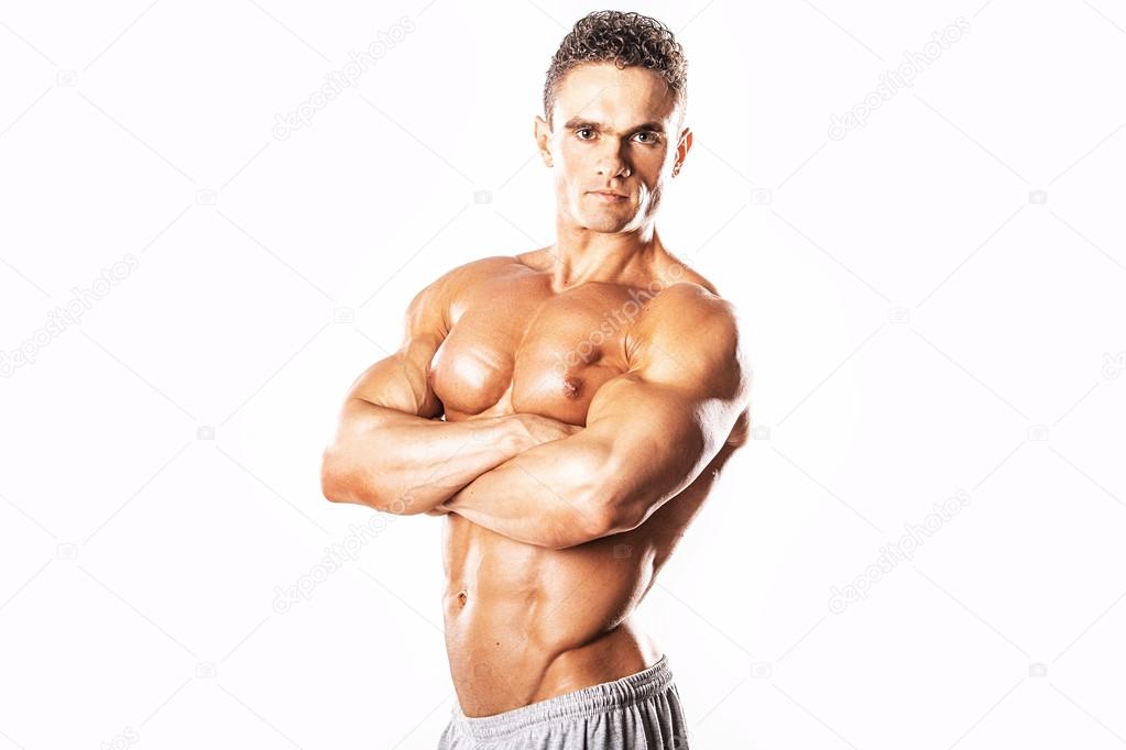 Strong Athletic Man showing muscular body and sixpack abs over white background.Muscular bodybuilder guy doing exercises with dumbbells over white background.Muscular man on white background