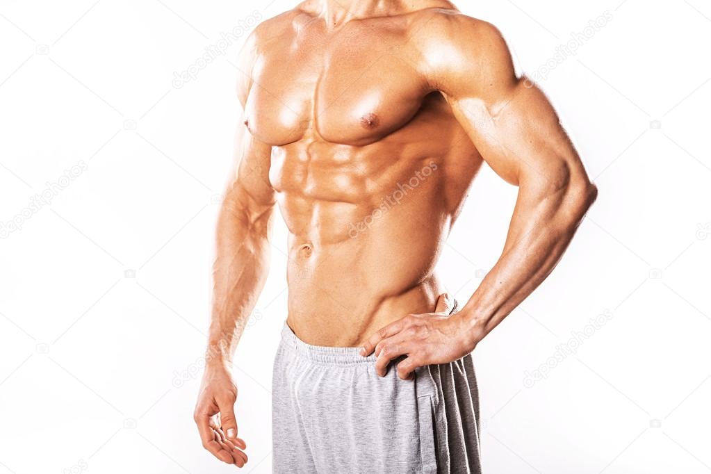 Strong Athletic Man showing muscular body and sixpack abs over white background.Muscular bodybuilder guy doing exercises with dumbbells over white background.Muscular man on white background