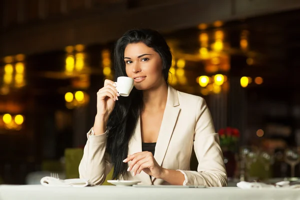 Πίνοντας καφέ κοπέλα στο τραπέζι στο εστιατόριο — Φωτογραφία Αρχείου