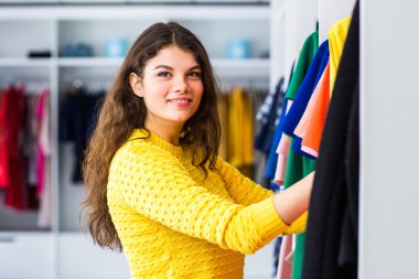 güzel genç kız üzerinde bir alışveriş shop.girl elbiseyle ölçer