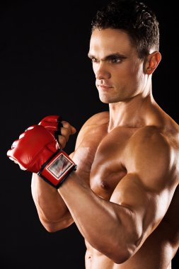 Güçlü atletik kas vücut siyah bir arka plan üzerinde gösterilen adam. Güçlü atletik kas body.muscular adam boks eldivenleri ile karışık anne için eldiven giymiş bir siyah background.muscular adam gösteren adam