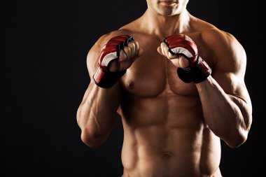 Güçlü atletik kas vücut siyah bir arka plan üzerinde gösterilen adam. Güçlü atletik kas body.muscular adam boks eldivenleri ile karışık anne için eldiven giymiş bir siyah background.muscular adam gösteren adam