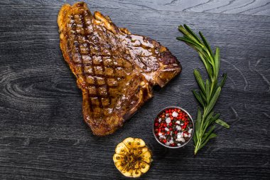 Sığır eti biftek. Baharat ve otlar bir rustik ahşap tahta üzerinde bir kopya alanı ile kaba ahşap masa üzerinde Marine Izgara Barbekü sığır eti parçası. Üstten Görünüm
