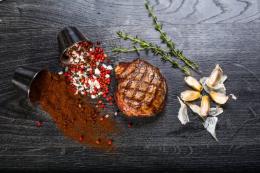 Sığır eti biftek. Baharat ve otlar bir rustik ahşap tahta üzerinde bir kopya alanı ile kaba ahşap masa üzerinde Marine Izgara Barbekü sığır eti parçası. Üstten Görünüm