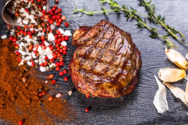 Sığır eti biftek. Baharat ve otlar bir rustik ahşap tahta üzerinde bir kopya alanı ile kaba ahşap masa üzerinde Marine Izgara Barbekü sığır eti parçası. Üstten Görünüm