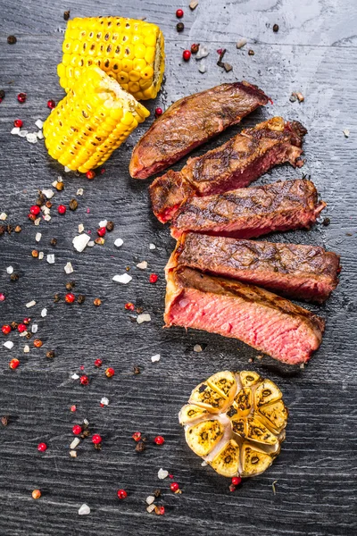 Beef steak. Piece of Grilled BBQ beef marinated in spices and herbs on a rustic wooden board over rough wooden desk with a copy space. Top view — Stock Photo, Image