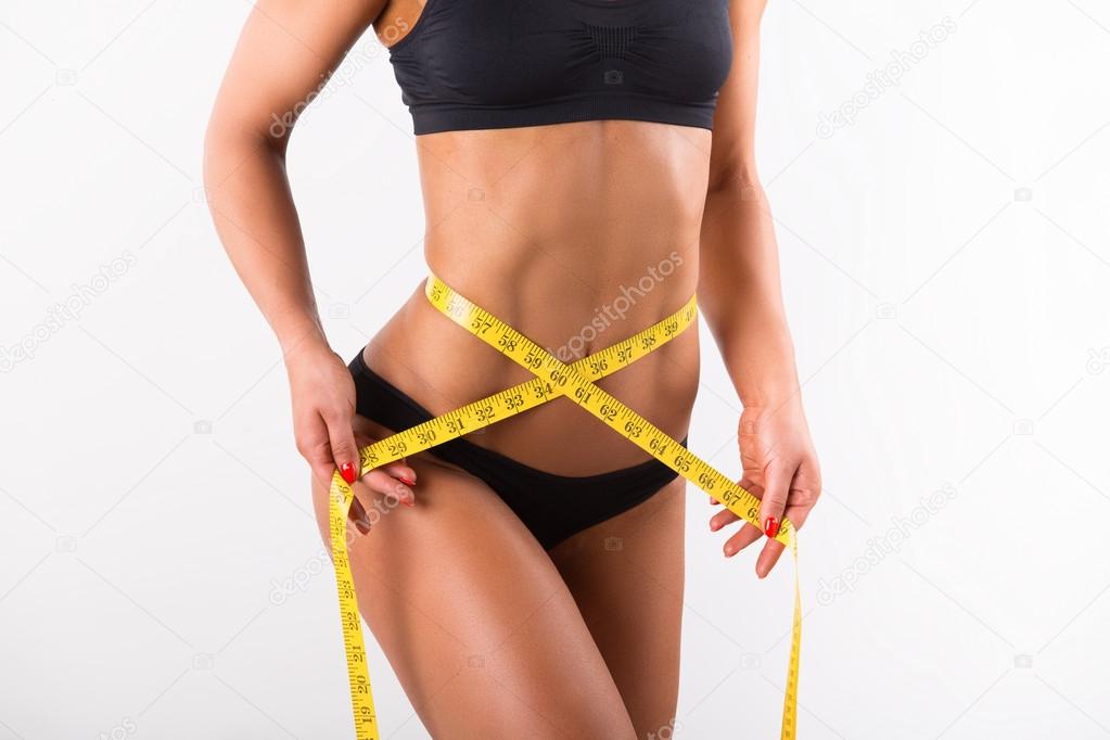 Woman measuring her slim body isolated on white background