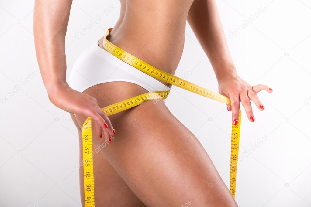 Woman measuring her slim body isolated on white background