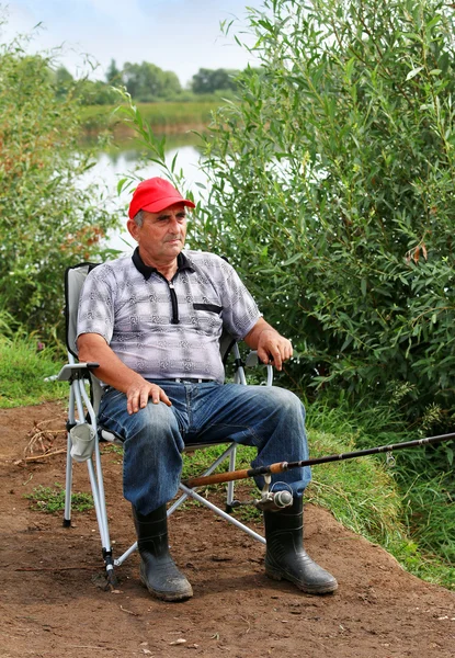 Pesce pescatore nel fiume. Uomo di mezza età . — Foto Stock