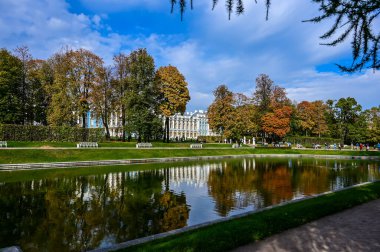 Sonbahar ormanı ve göldeki yansıma. Dramatik sıradışı sahne. Kırmızı ve sarı sonbahar yaprakları. Güzellik dünyası.