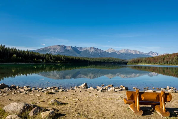 En vacker bänk för avkoppling vid sjön. Klart vatten från en fjällsjö. Pyramidberget vid Pyramidsjön — Stockfoto