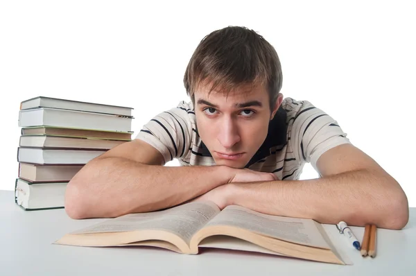 Estudante masculino na mesa com pilha de livros — Fotografia de Stock