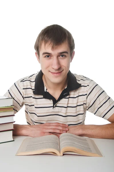 Estudante masculino na mesa com pilha de livros — Fotografia de Stock