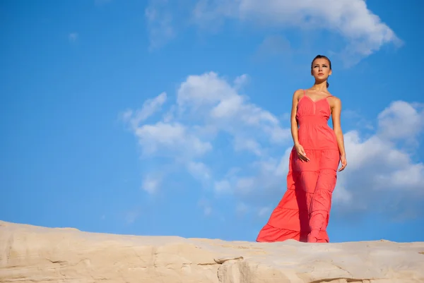 Mulher de beleza em vestido vermelho no deserto — Fotografia de Stock