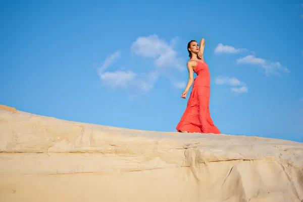Schoonheid vrouw in rode jurk op de woestijn — Stockfoto