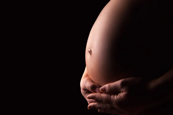 Силуэт беременной женщины на черном фоне — стоковое фото