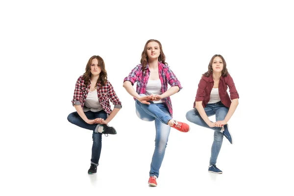 Three young women dancing over white background — Stock Photo, Image
