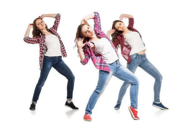 Drei junge Frauen tanzen vor weißem Hintergrund — Stockfoto