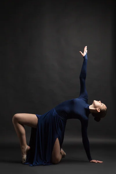 Bailarina posando en vestido azul sobre fondo oscuro — Foto de Stock