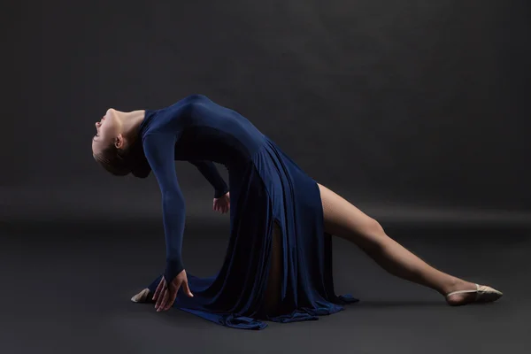 Poser danseuse en robe bleue sur fond sombre — Photo