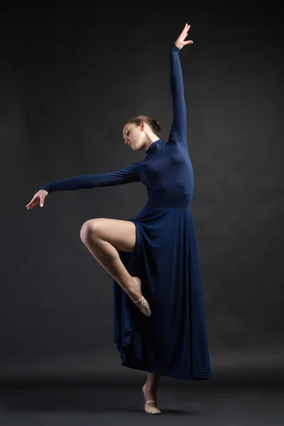 Posing dancer in blue dress over dark background — Stock Photo, Image