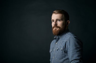 Koyu arka plan üzerinde kırmızı sakallı adam stüdyo portre