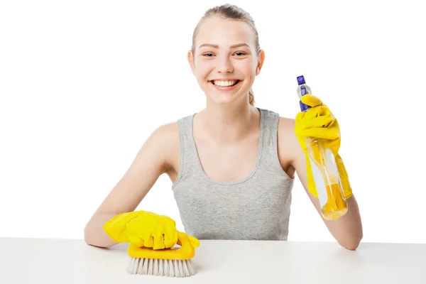 Jonge vrouw met scrub borstel en reinigende spray geïsoleerd — Stockfoto