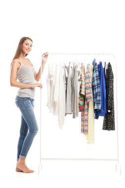 Elbise askısı yakınındaki güzel genç esmer yan görünüm