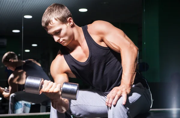 Retrato del hombre musculoso guapo haciendo rizos de concentración en el banco — Foto de Stock