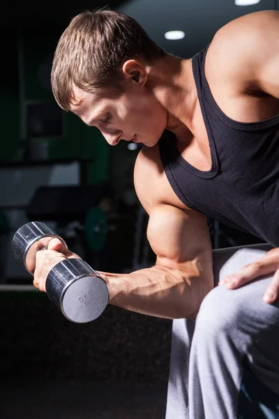 Primer plano del joven haciendo rizos de concentración con mancuerna — Foto de Stock