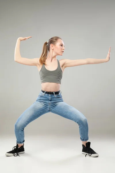 Menina em pose de artes marciais sobre fundo cinza — Fotografia de Stock