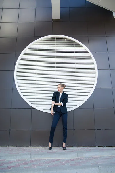 Stylish woman against of ventilation system in building wall — Stock Photo, Image